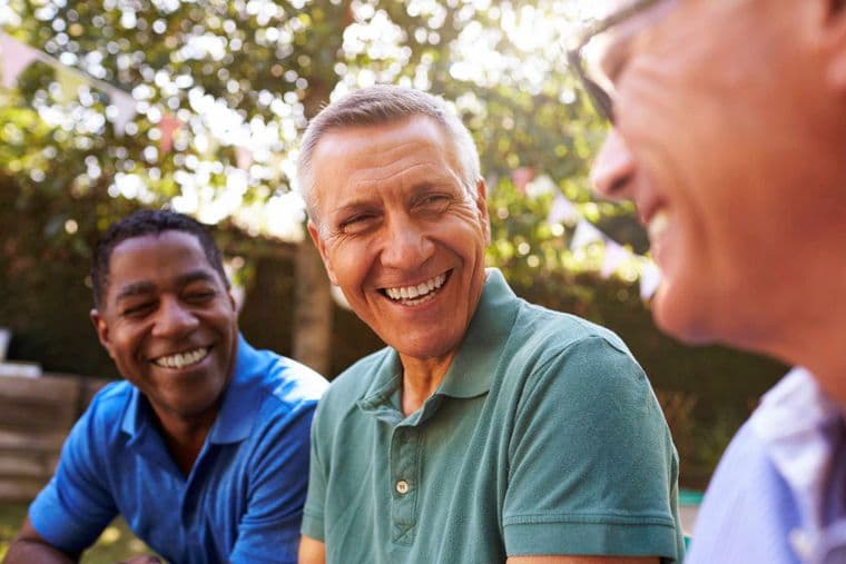 Group of three older men laughing