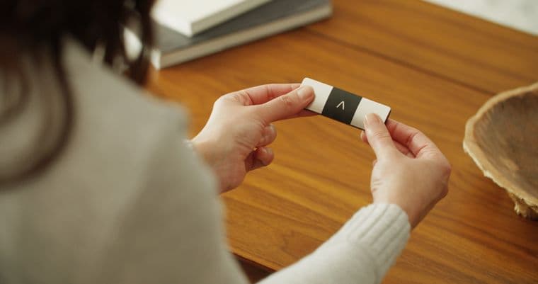 A woman using a KardiaMobile portable ECG recording device